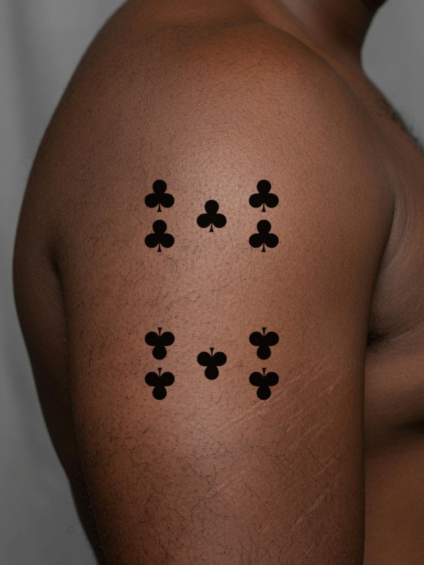 10 of Clubs pip tattoo on the upper arm
