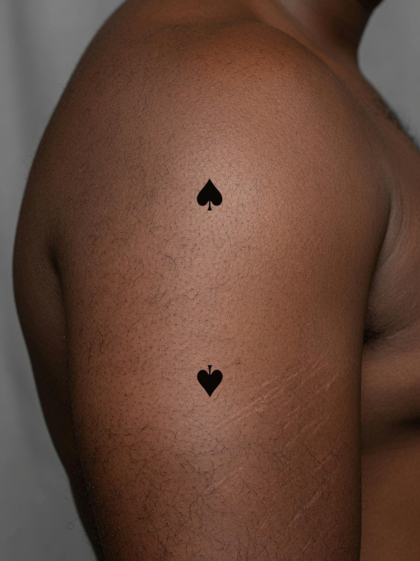 2 of Spades pip tattoo on the upper arm
