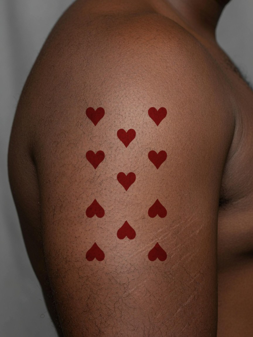 Jack of Hearts pip tattoo on the upper arm
